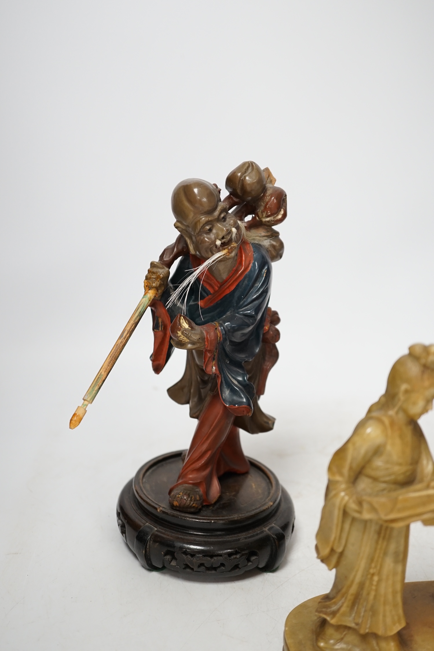 Two Chinese Fuzhou lacquer figures of Shou Lao and a smaller soapstone figure group, tallest Fuzhou figure 25cm high (3). Condition - some wear but fair